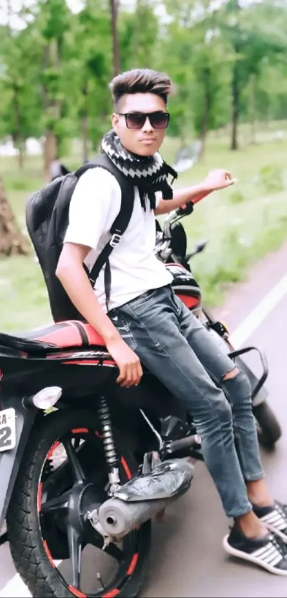 Young biker on motorcycle by a scenic road in nature.