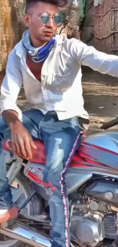 Biker wearing sunglasses sits stylishly on a motorcycle in the sunlight.