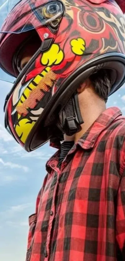 Person in graphic helmet with plaid shirt and blue sky background.