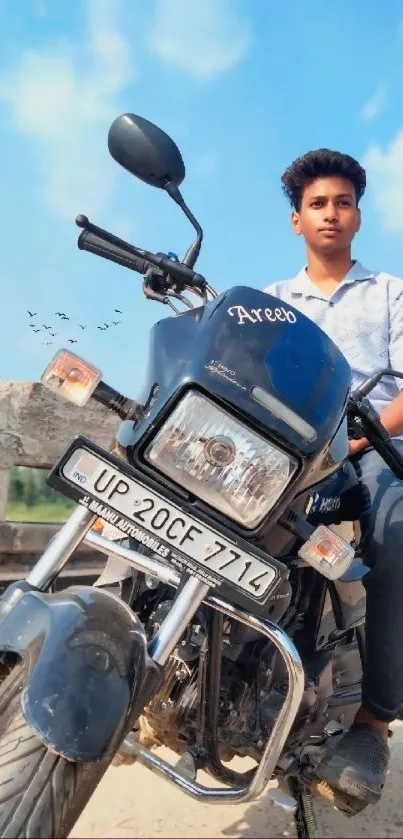 Young rider on motorcycle under blue sky.