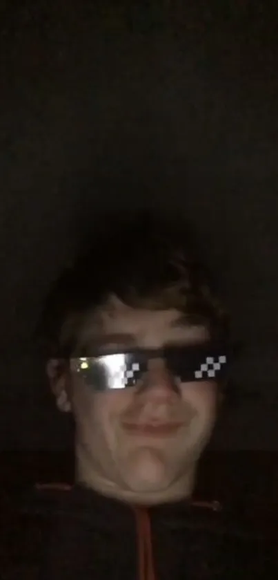 Young man wearing pixelated sunglasses in the dark.