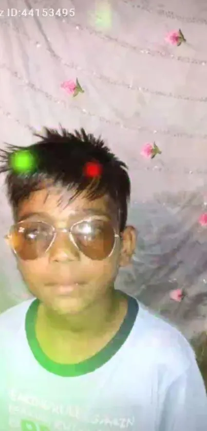 Boy with sunglasses, floral backdrop and colored lights.