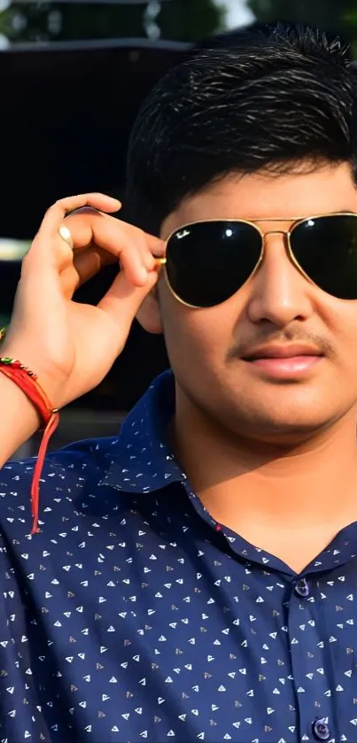 Fashionable man wearing sunglasses and navy shirt.