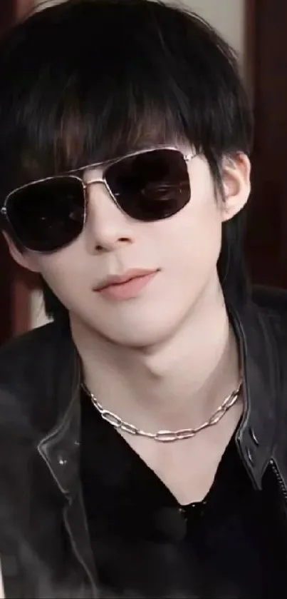 Stylish individual wearing sunglasses and a leather jacket.