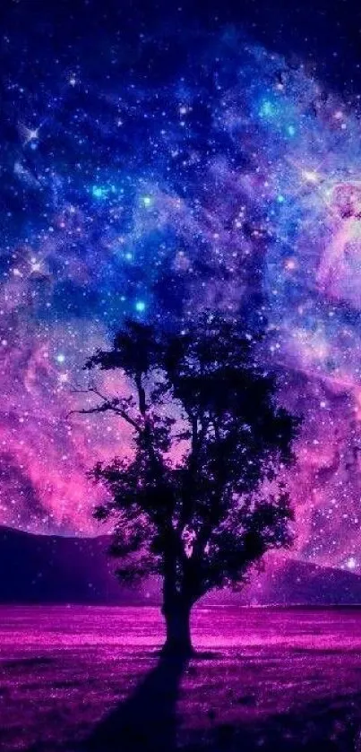 Silhouetted tree with a vibrant galaxy background on mobile wallpaper.