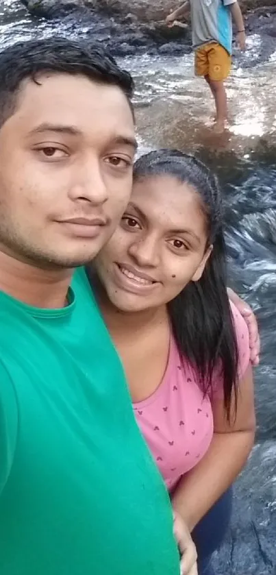 Couple standing by a scenic river enjoying nature.