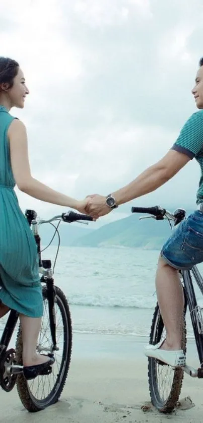 Couple on bicycles by the beach, holding hands and enjoying a scenic ocean view.