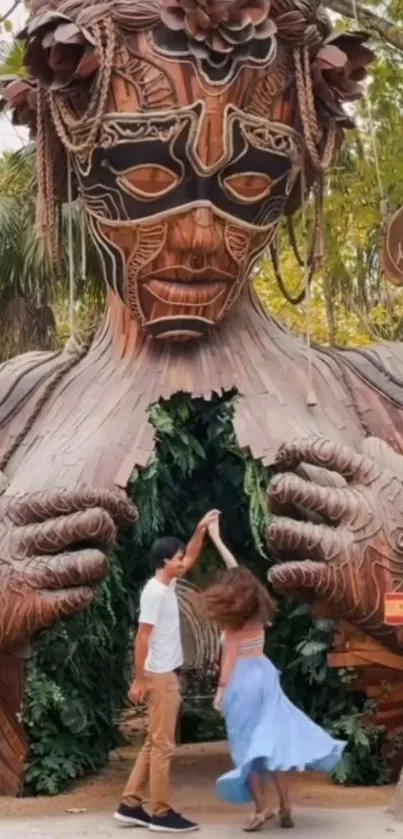 Couple dances under large wooden sculpture.