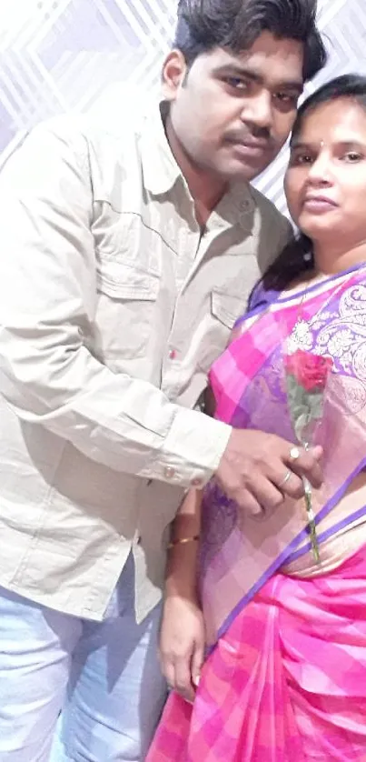 Couple in traditional attire with a rose.