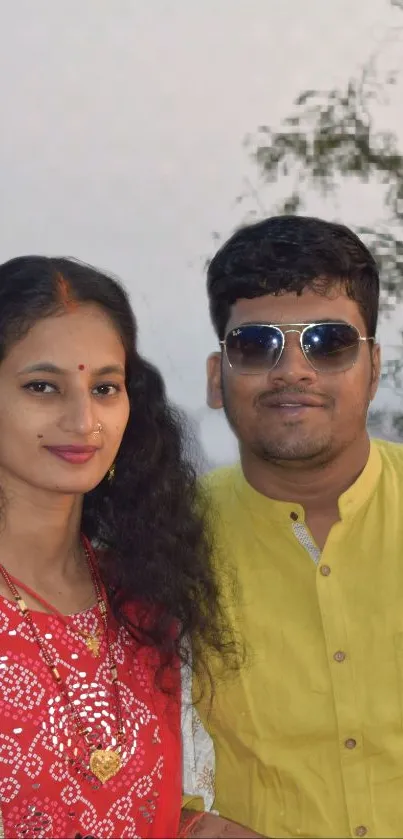 Couple in colorful traditional attire embracing cultural elegance.