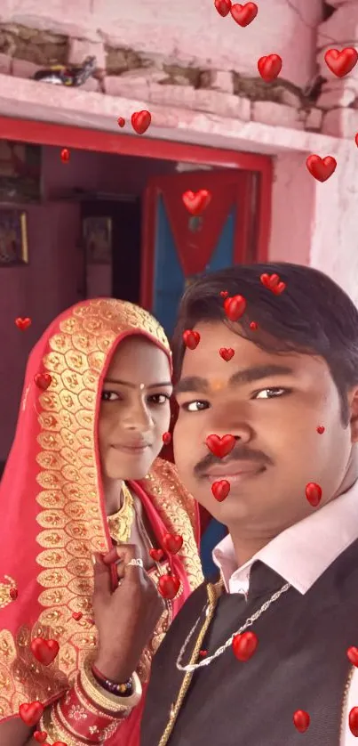 Indian couple in red attire with hearts imagery.