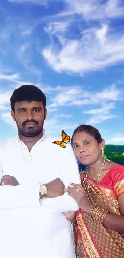 Couple in traditional attire with blue sky and green fields.