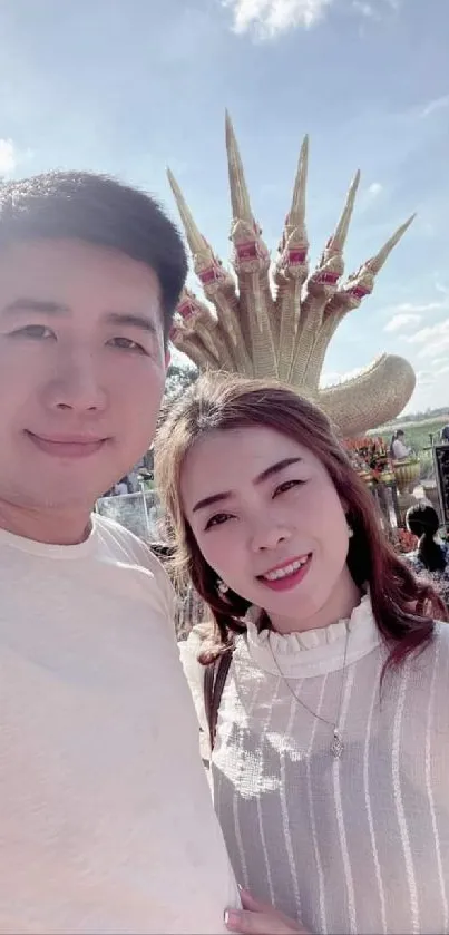 Couple smiling under a sunny blue sky.