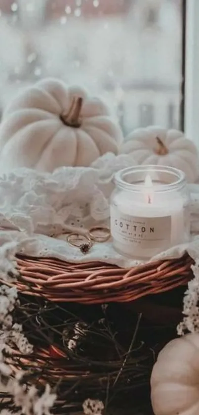 Cozy autumn scene with candles, pumpkins, and lace on a windowsill.