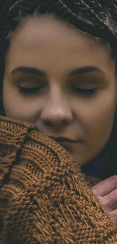 Woman in braided hairstyle with warm brown sweater.