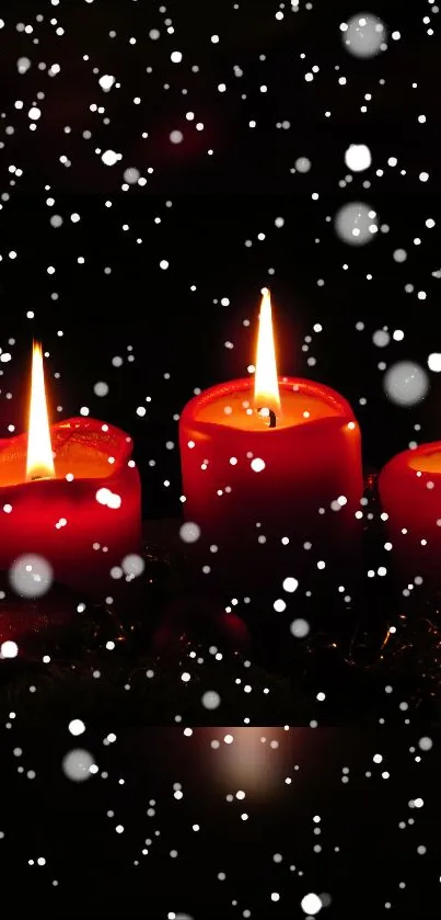 Three red candles in snow create a warm, festive winter scene.