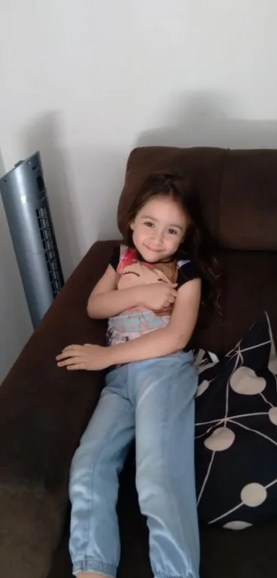 Smiling child lounging comfortably on a brown sofa in a cozy living room.