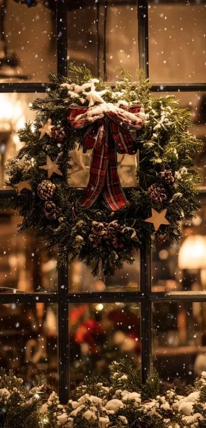 Festive window with Christmas wreath and snowfall.