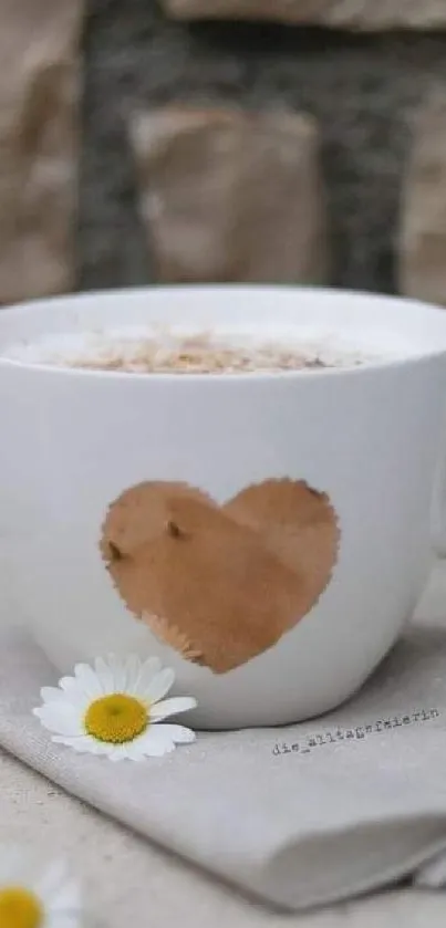 White coffee cup with heart design and daisies on beige background.