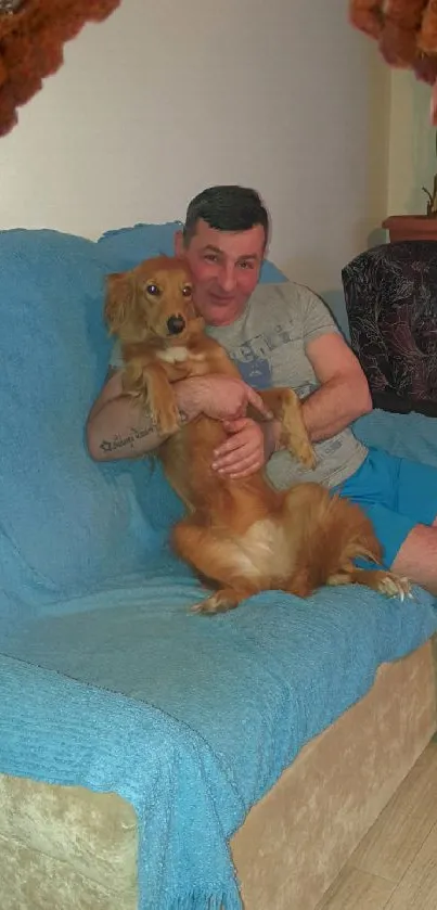 Man with dog on blue couch with brick frame.