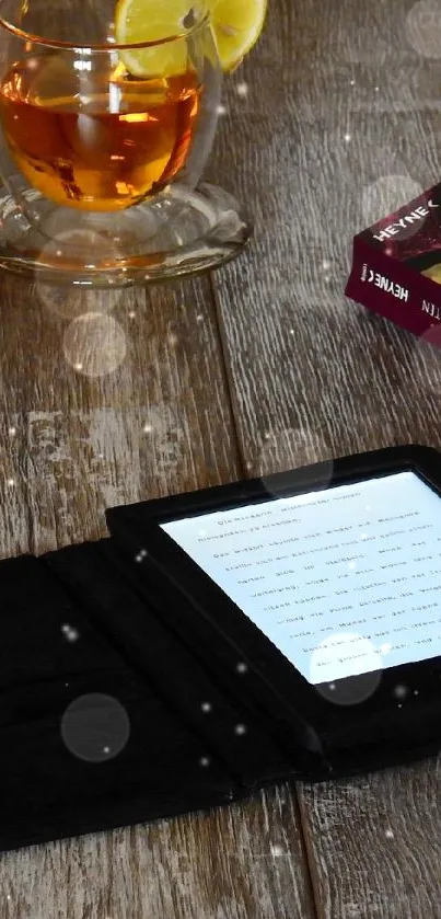 Cozy setup with eBook reader, books, tea, and spectacles on a wooden table.