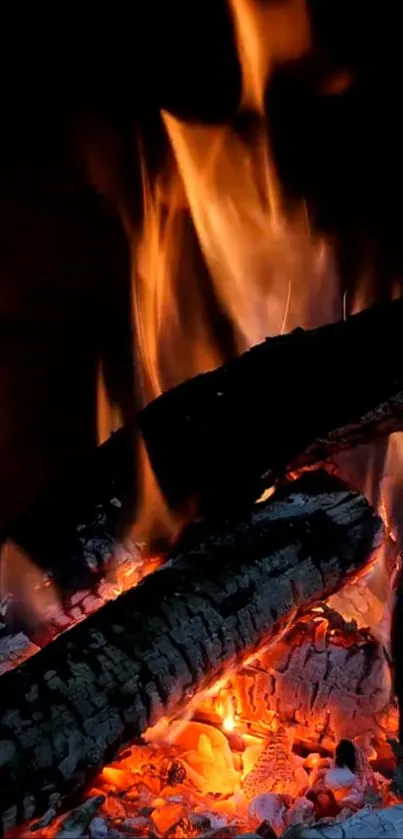 Mobile wallpaper of burning logs with glowing flames and dark background.