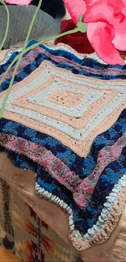 Colorful crochet blanket with pink accent.