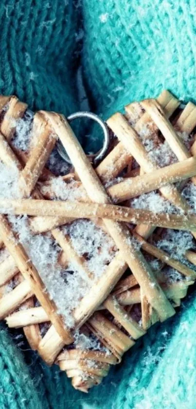 Teal gloves holding a wicker heart with snow.