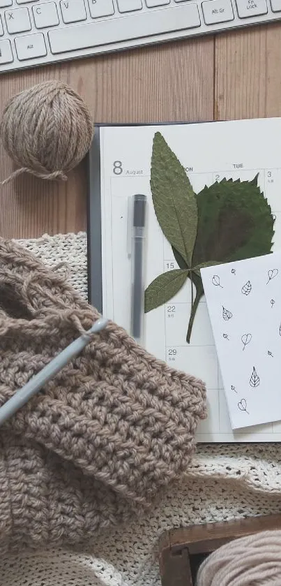 Cozy knitting workspace with yarn and calendar on wooden desk.