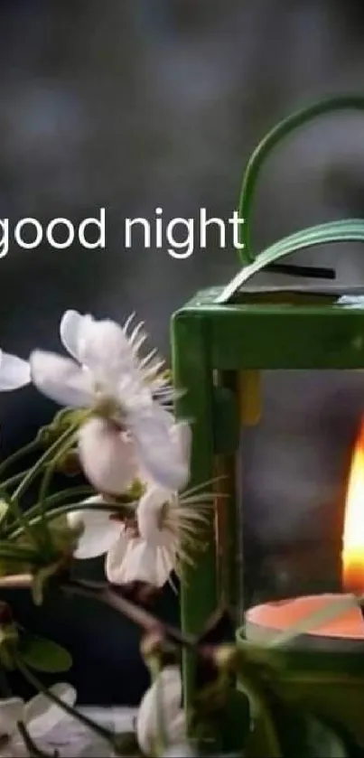 Candle-lit lantern with white flowers and 'good night' text.