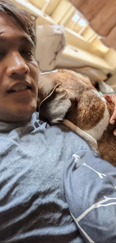 Person cuddling with a dog in a cozy home setting.