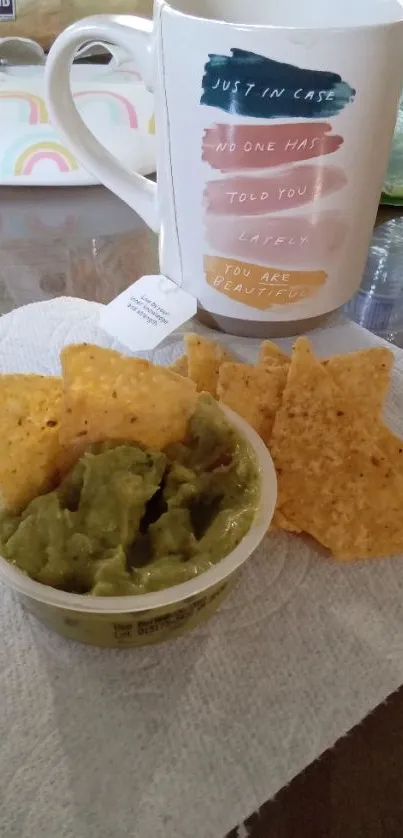 Ceramic mug with tortilla chips and guacamole on a cozy kitchen table.