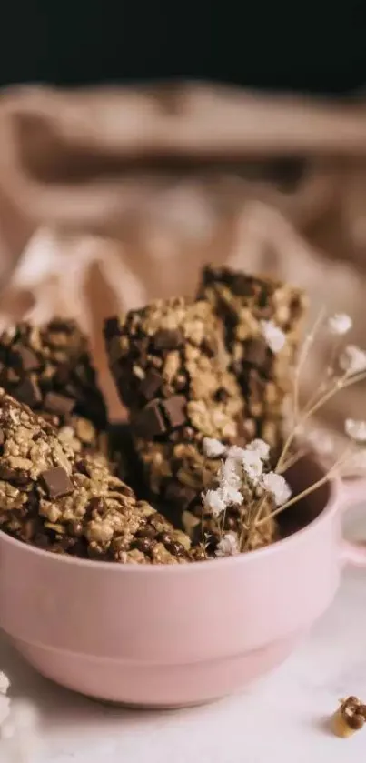 Chocolate oat bars in a pink cup with a beige background.