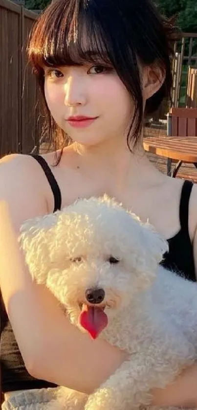 Young woman sitting outdoors with a white fluffy dog in cozy evening light.