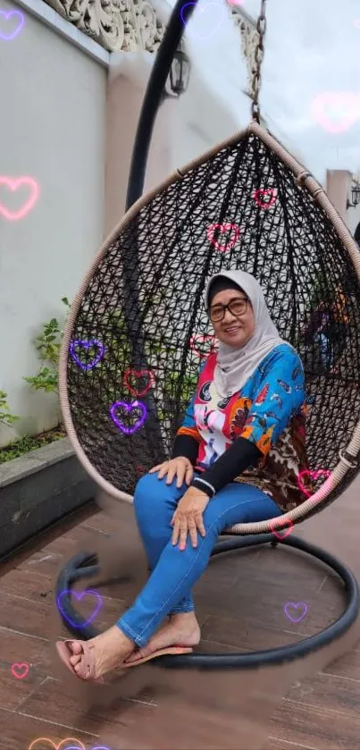 Woman relaxing on outdoor swing with heart patterns.