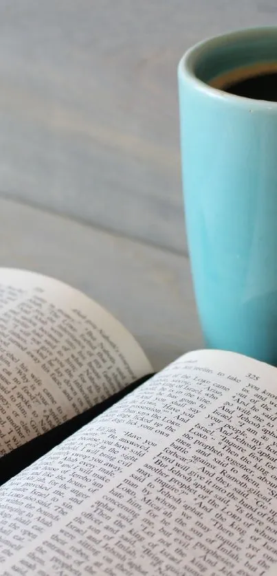 Teal mug of coffee next to an open book on a wooden table.