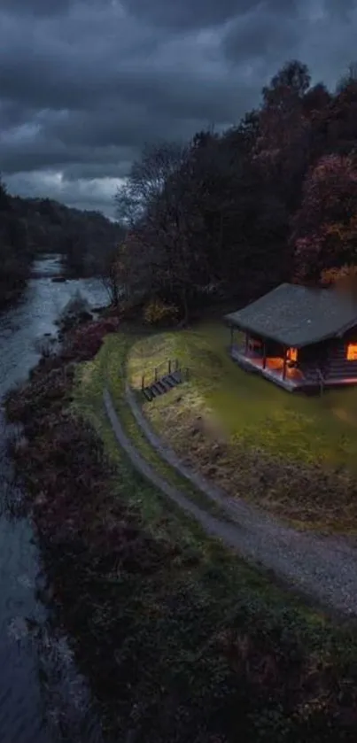 A cozy cabin by a river at dusk with a dark, moody sky.