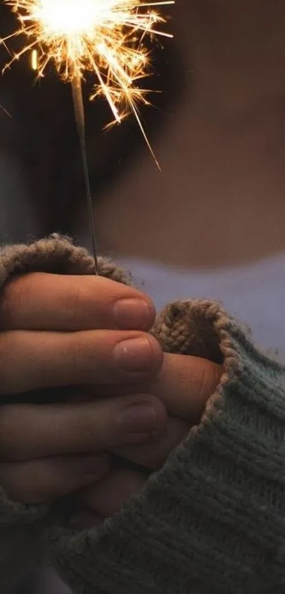 Hands holding sparkler with woolen gloves.