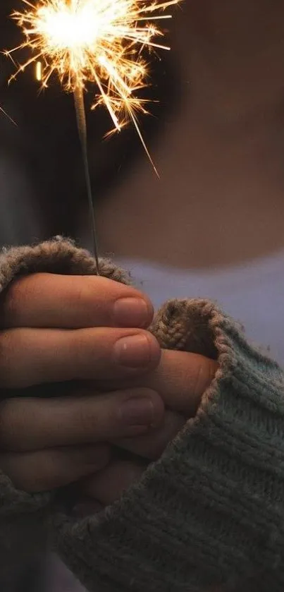 Hands holding a sparkler in cozy knit sleeves, glowing softly.