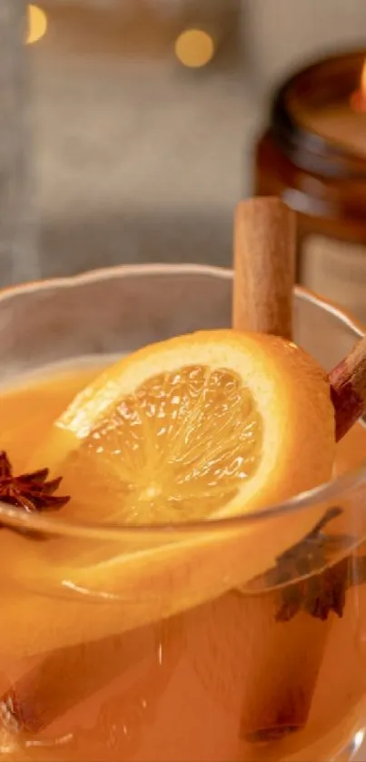 Warm spiced tea with orange slices and cinnamon in a glass cup.