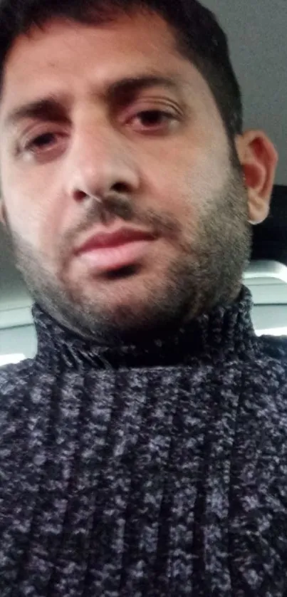 Close-up of a person in a textured black sweater.