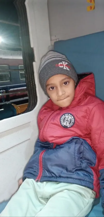 Child in cozy attire during a train journey.