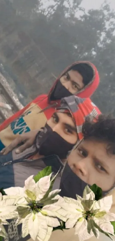 Group selfie in winter clothing with floral overlay in nature.