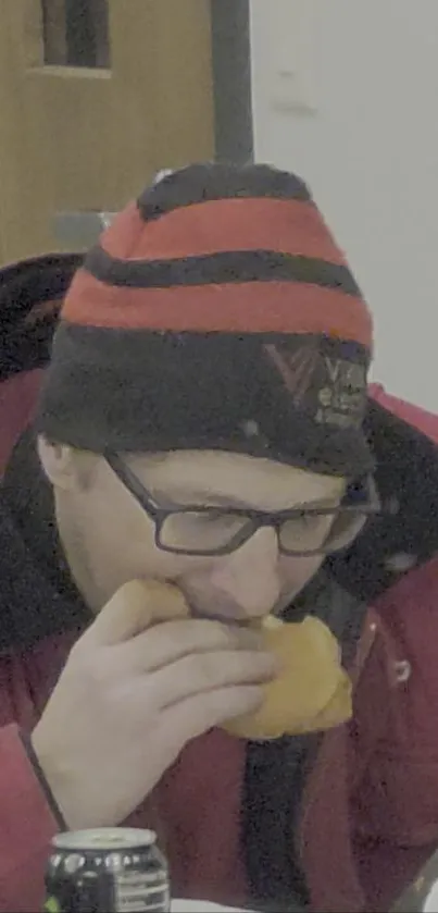 Person in red jacket enjoying a snack.