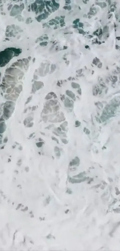 Aerial view of crashing ocean waves creating white foam.