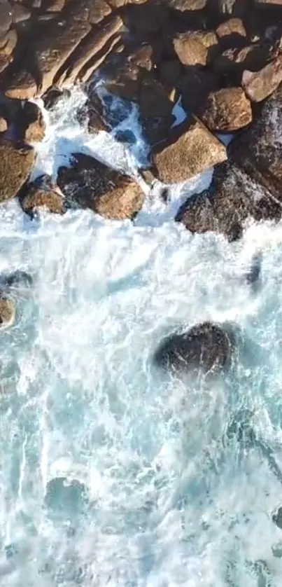 Crashing ocean waves on a rocky coastline, top view.