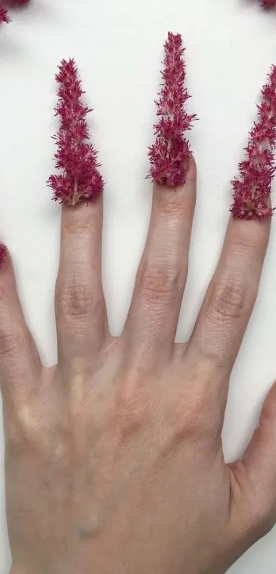 Creative floral hand art with magenta petals on fingers.