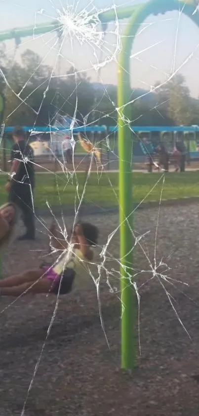 Swing set in park with cracked screen effect overlay.