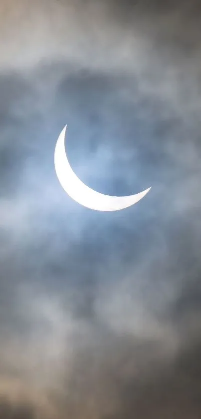 Crescent moon surrounded by clouds in a serene night sky backdrop.