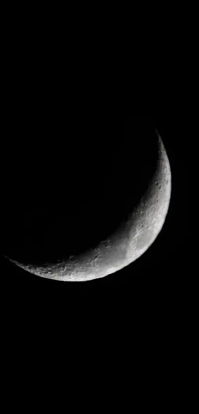 Crescent moon against a black sky, creating a minimalist night scene.